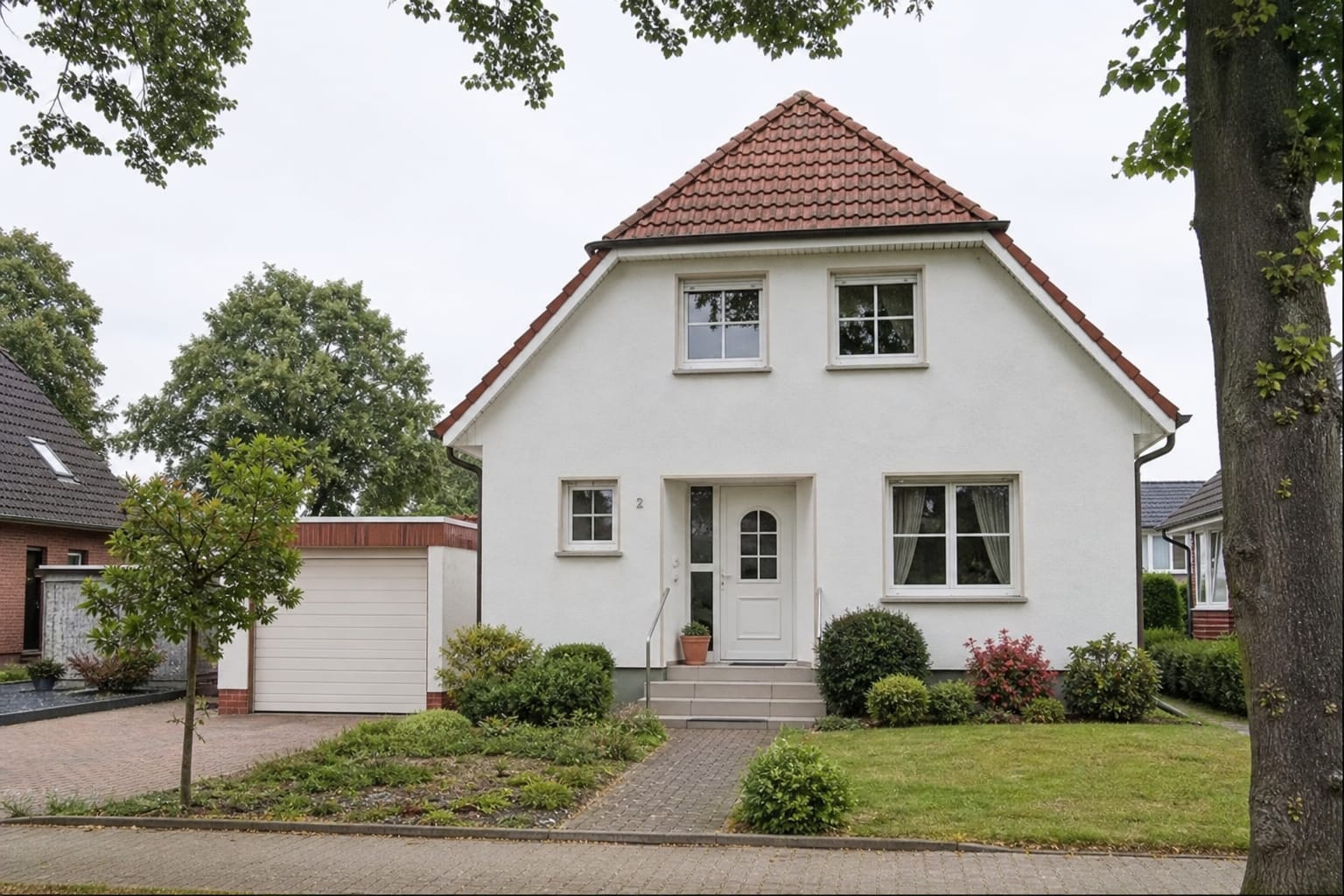 Modernes freistehendes Einfamilienhaus mit großen Fenstern und Garten